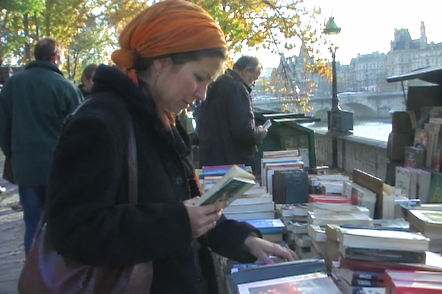 Женщина выбирает книги на развале у набережной