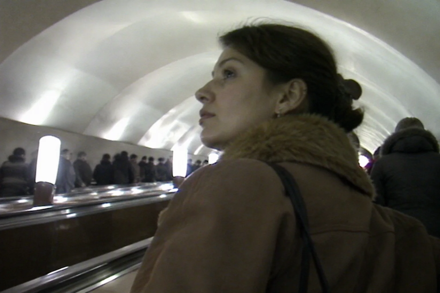 Девушка поднимается по эскалатору московского метро