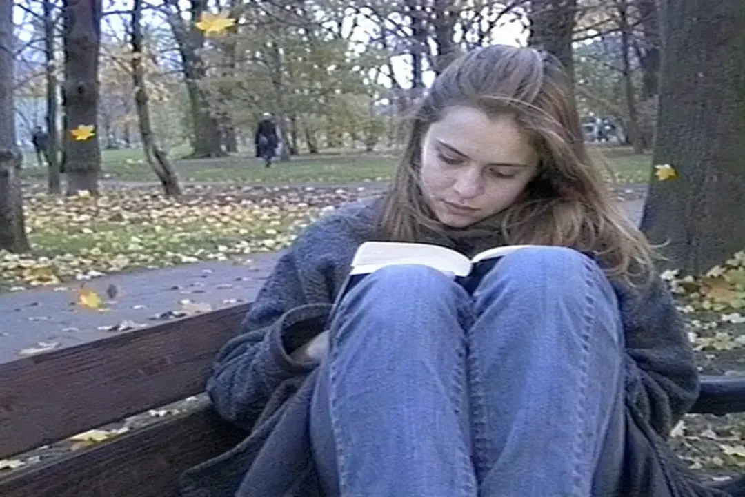 Девушка с книгой на скамейке в парке